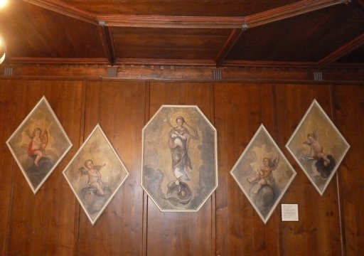 5 Gemälde aus dem Kloster 5 Bildtafeln mit Madonna und Engeln hängen an einer Holfgetäfelten Wand.