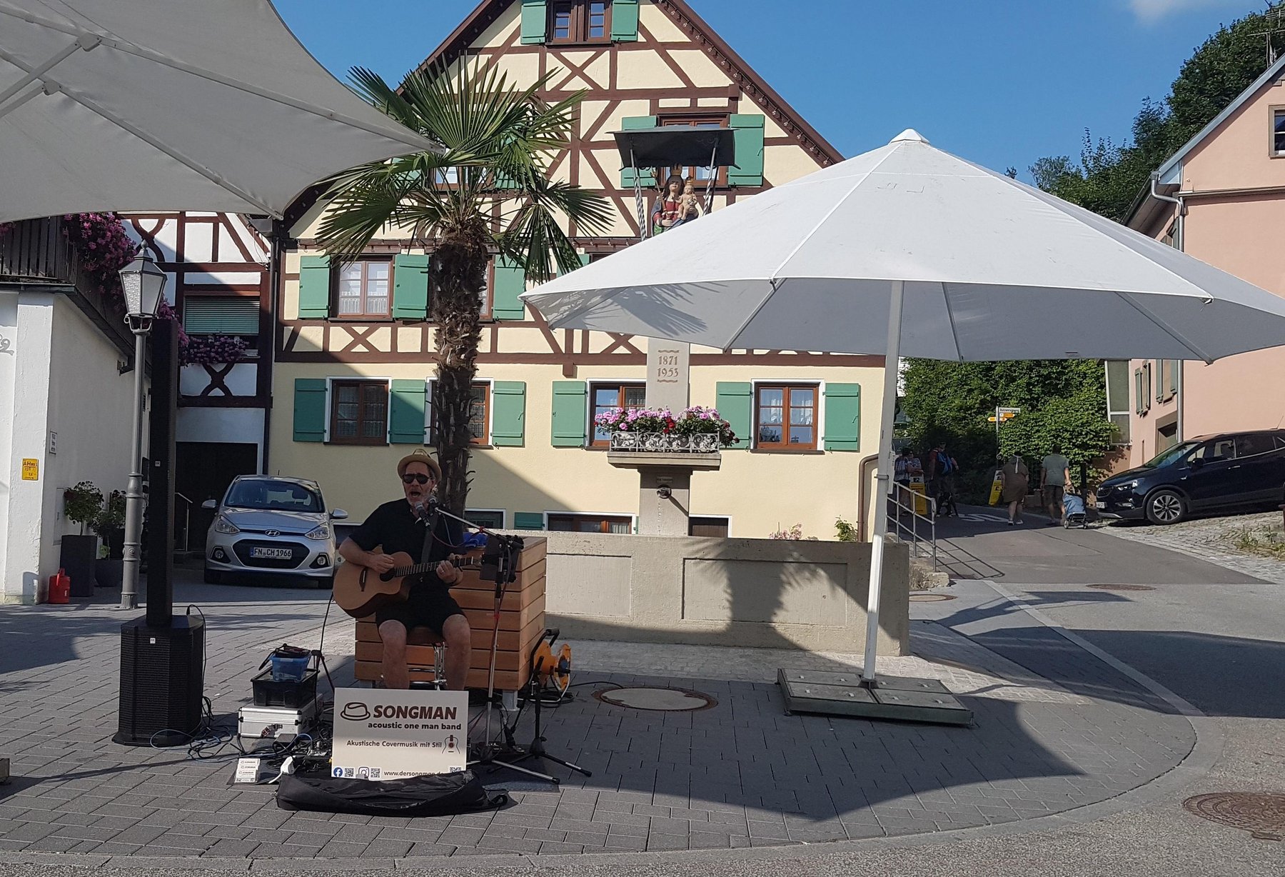 Sänger mit Gitarre musiziert vor dem Marienbrunnen auf dem Platz